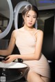 A woman sitting in front of a sink in a bathroom.