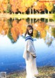 A woman standing in front of a body of water.