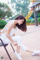 A woman sitting on a chair in a park.